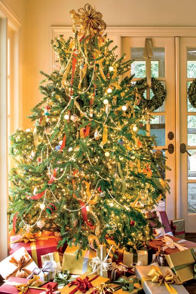 Elegant formal salon tree with pearl garlands and silk ribbon, limestone fireplace, soft chandeliers