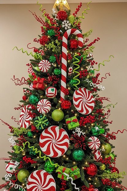 Tree with peppermint shaped ornaments and green foliage in a bright room