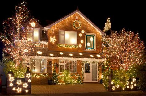 Living room window framed in warm fairy lights with linen curtains and wooden side table