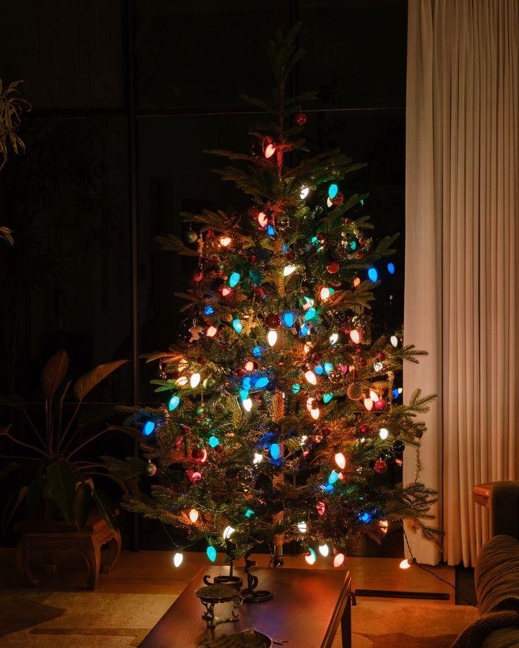 Window frame christmas lights hung crookedly without symmetry or balance across pane glass.