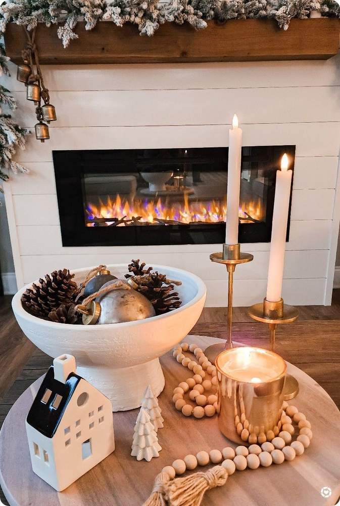 Rustic woodland Christmas coffee table decor featuring dark pinecones and tall brass taper candles.