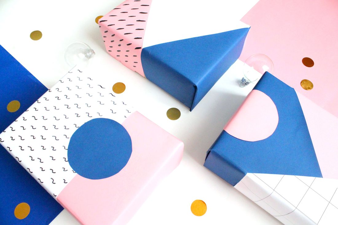 Gift‑giving station, geometric patterned paper, pink and blue tones, warm pendant light