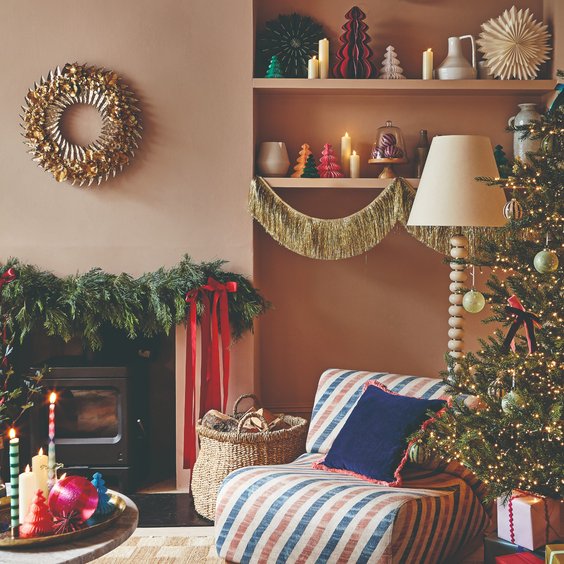 Pastel living room with pale pink walls featuring soft flocked evergreen garland and champagne lighting