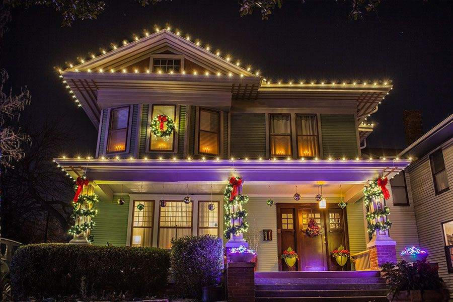 Unshielded bright string lights crisscrossed overhead creating harsh glare above a dining table setting.