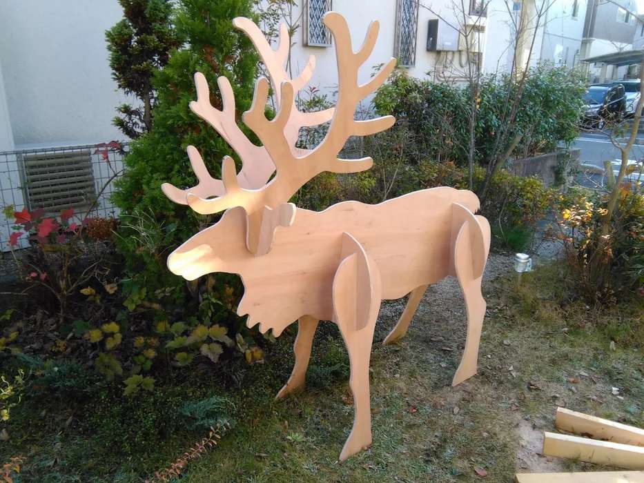 Handcrafted plywood reindeer silhouettes standing in a snowy lawn as outdoor christmas decorations.