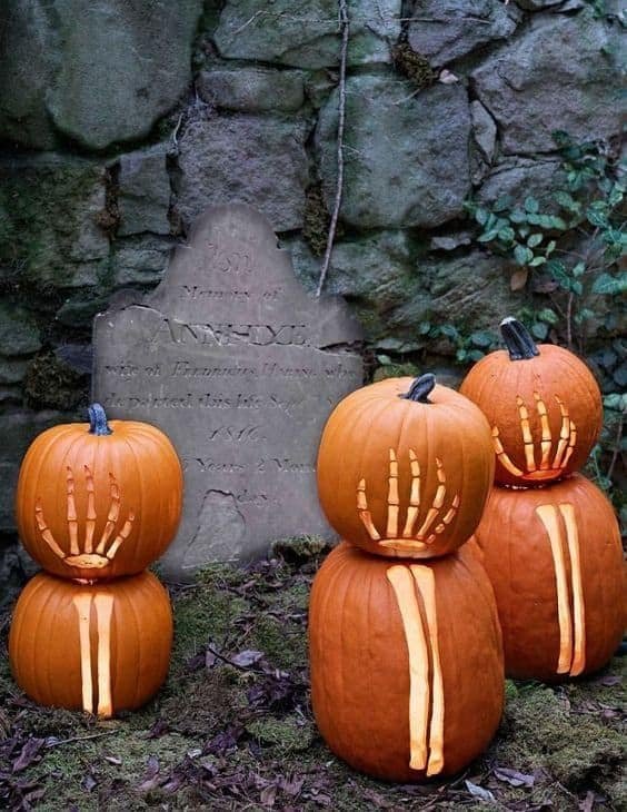 Porch or foyer with a witch silhouette pumpkin, dark metal lanterns, moody decor.
