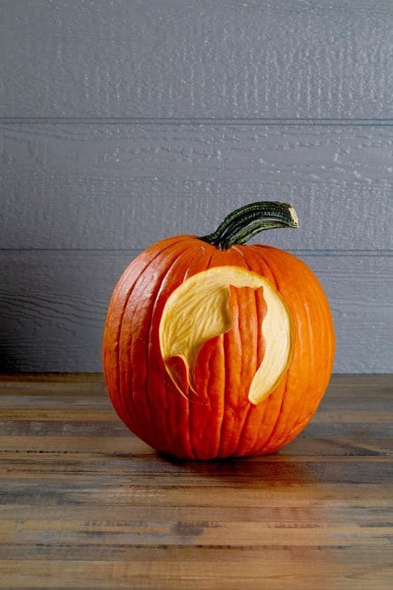 A navy blue painted pumpkin with tiny drilled holes forming a glittering star constellation pattern.