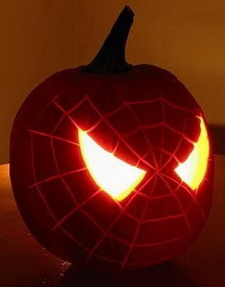 A pumpkin carved with a detailed fox silhouette sitting in a forest-themed entryway.