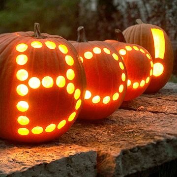 A pumpkin decorated with a dreamcatcher design carved and painted with gold accents.
