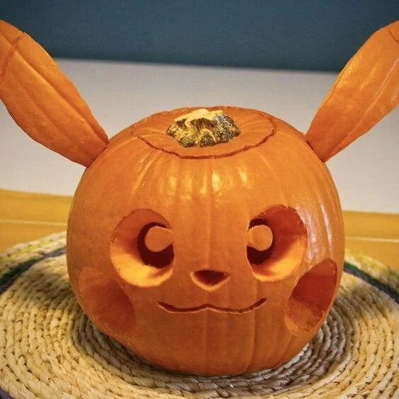 A pumpkin with a sophisticated, flowing calligraphy swirl carved into its skin.