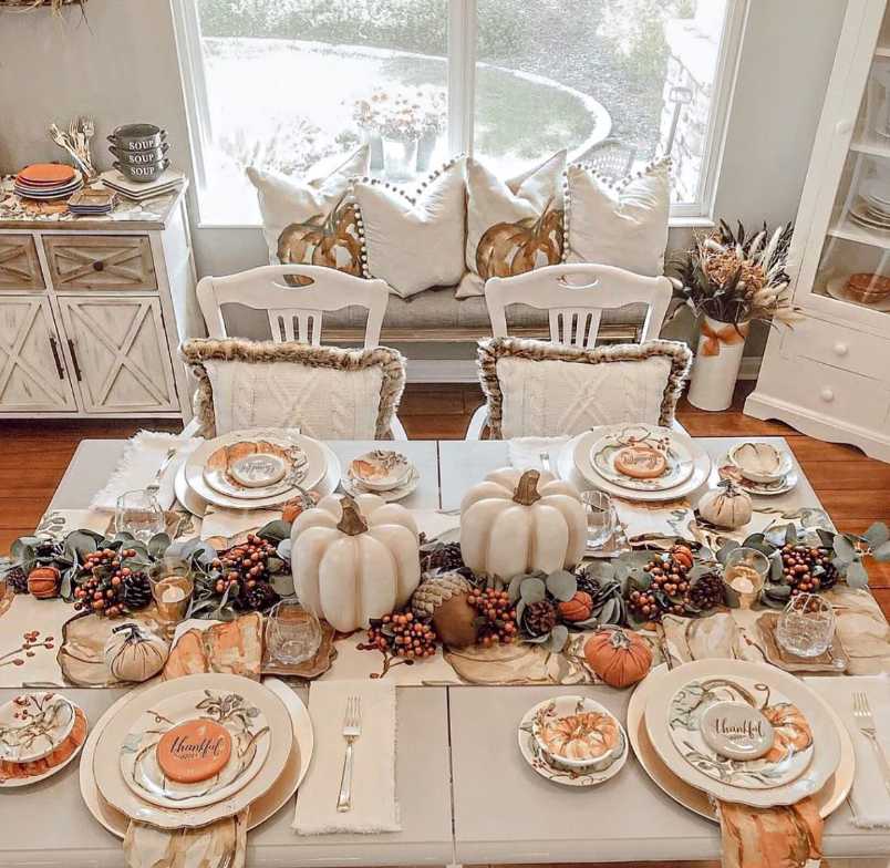 Rustic farmhouse, layered pumpkin arrangement, handwritten “Thankful” sign, reclaimed wood table, soft amber lighting