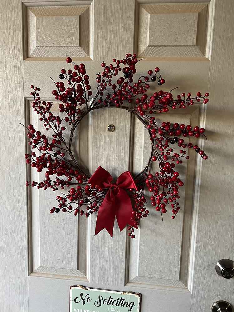 Vibrant artificial red berry wreath with a glossy finish for a bold holiday statement.
