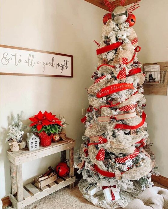 Cozy lodge living room tree with red burlap ribbon, leather armchair, stone fireplace, warm firelight