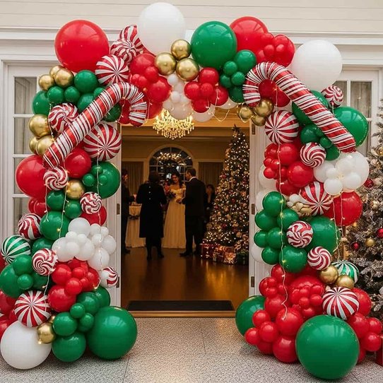 Living room doorway framed with organic red, chrome gold, and forest green balloon archway
