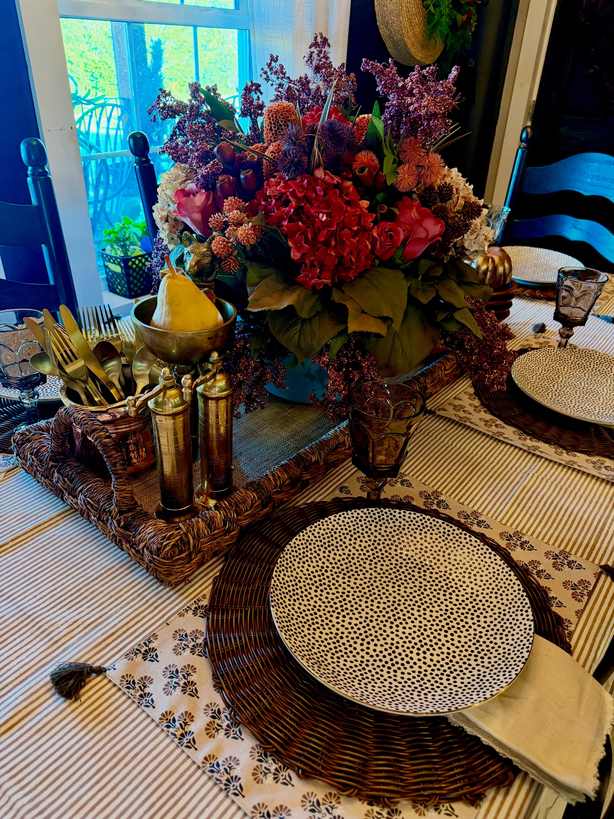 Formal dining room, red hydrangea centerpiece, gold flatware, pear fruit, crisp white tablecloth, soft lighting.