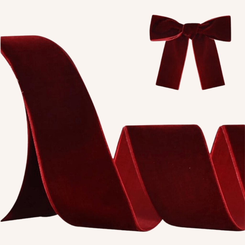 Thick red velvet ribbon tied in a bow on a white gift box with a gold tag.