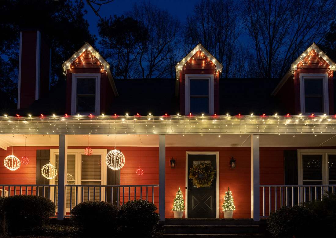 A home roofline outlined in alternating red and white LED bulbs as outdoor christmas decorations.