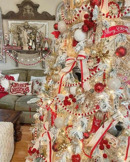 Rustic family room with red white ribbon tree near stone hearth under soft lamp illumination