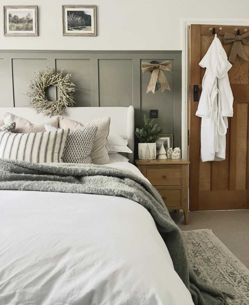 Bedroom with rustic wreath and burlap bows, wooden furniture, and warm light.