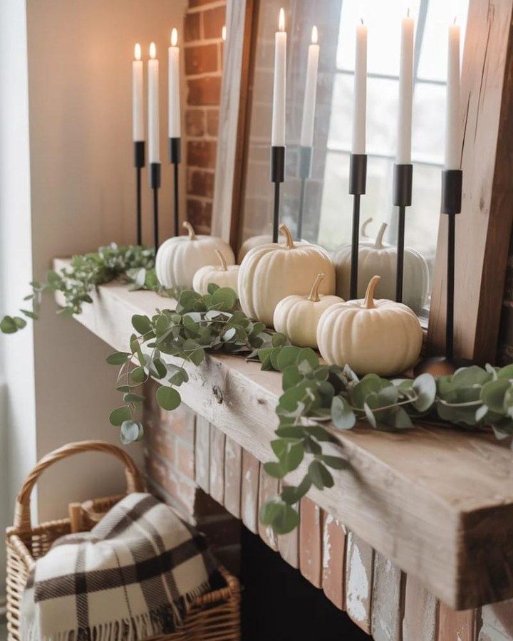 Living room mantel, white ceramic pumpkins, fresh eucalyptus garland, reclaimed barn wood mantel, warm pendant lighting.