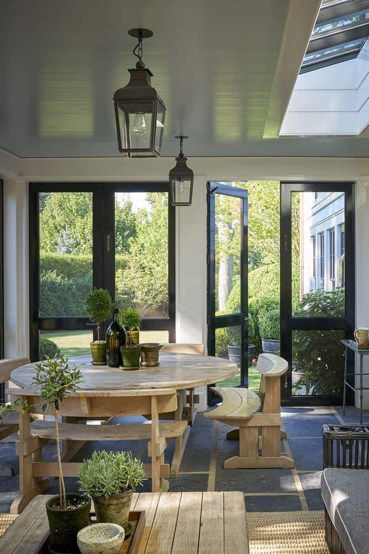 Screened in porch dining area with a skylight, hanging lanterns, and modern furniture.