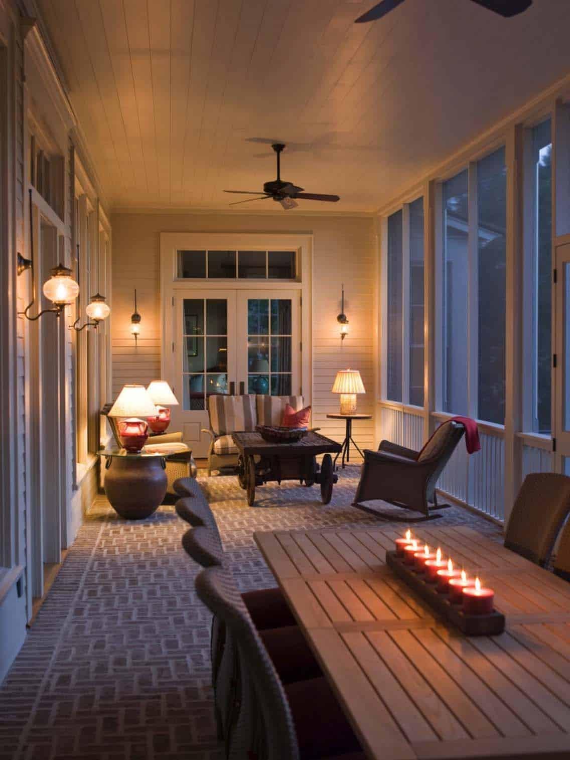 Screened in porch with rocking chairs, warm table lamps, and a cozy evening atmosphere.