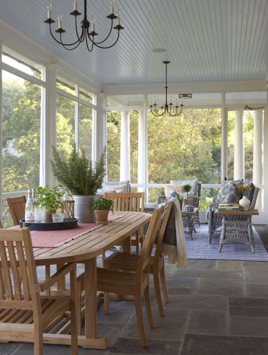 Screened in porch ideas sofa stone fireplace featuring deep cushions and a cozy atmosphere.
