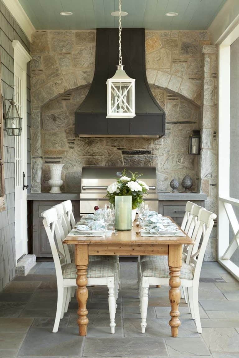 Screened in porch ideas stone grill dining lantern with a functional outdoor kitchen setup.
