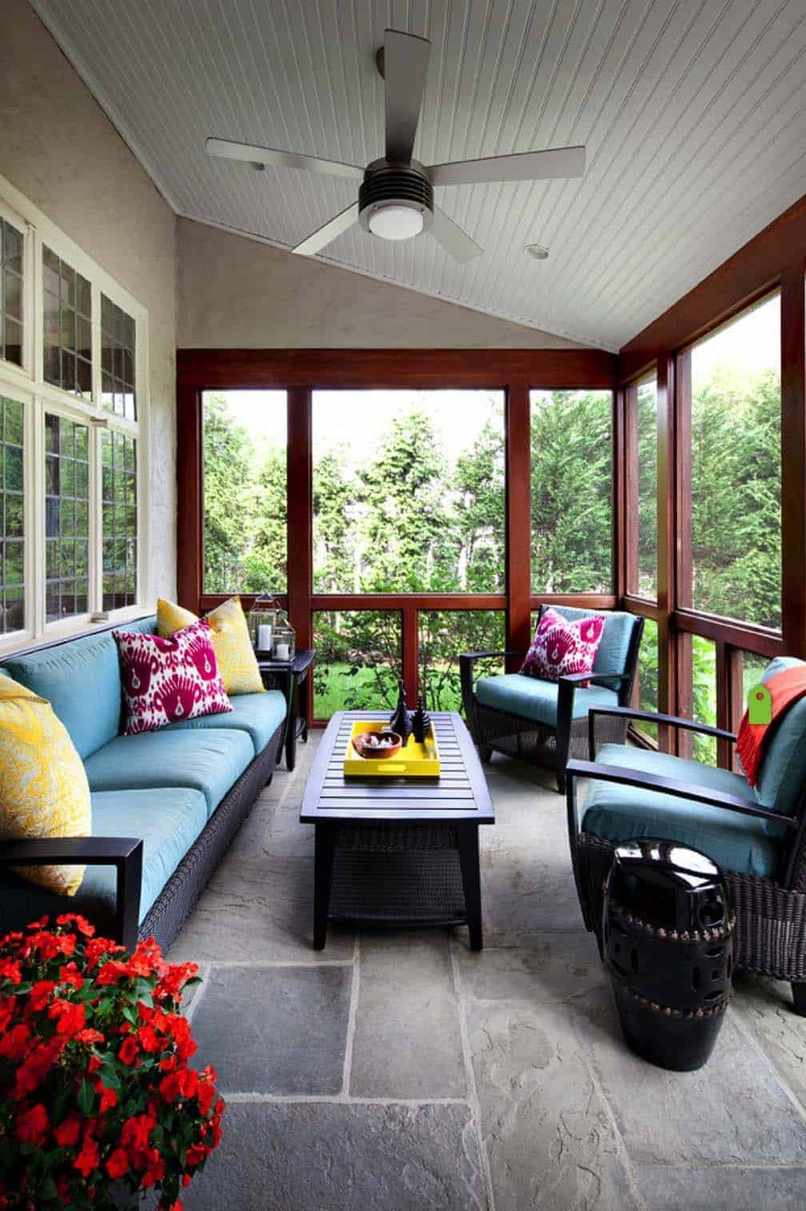 Screened in porch ideas turquoise sofa colorful pillows featuring a fun and bright decor palette.
