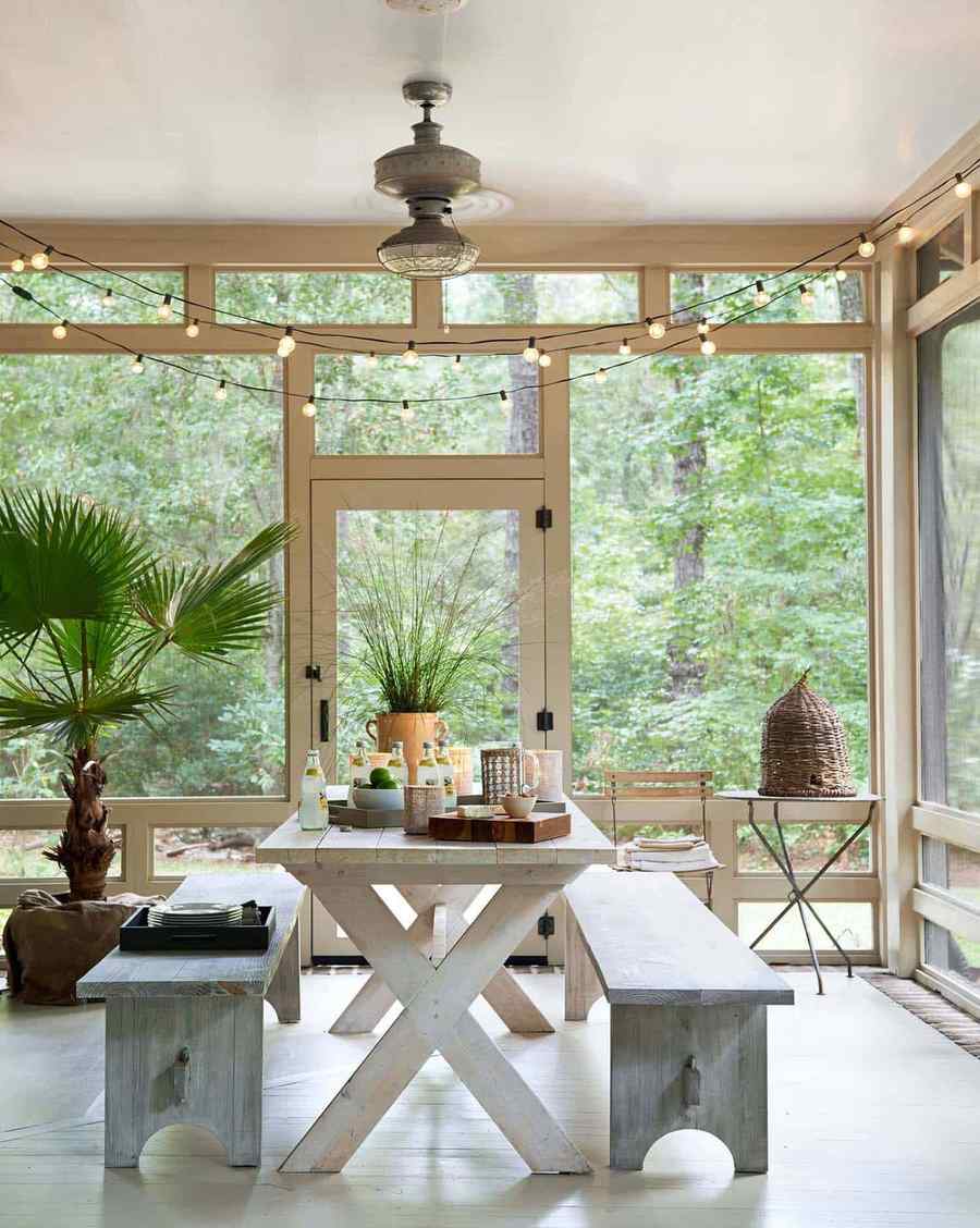 Screened in porch ideas white table string lights perfect for intimate summer evening dining.