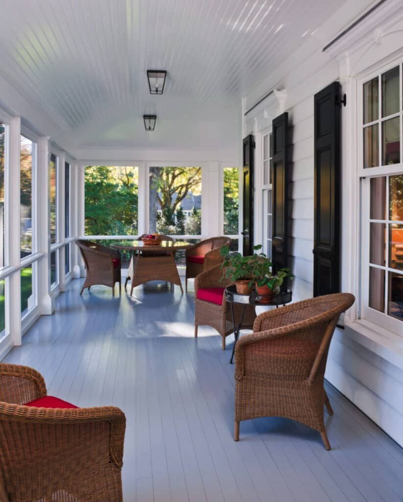 Screened in porch ideas white wicker red cushions featuring timeless contrast and comfort.