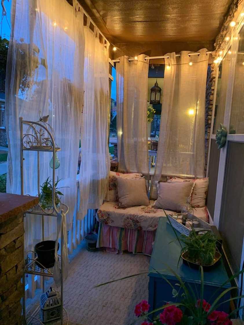 Shabby‑chic balcony with sheer drapes, a vintage daybed, and pastel accessories.