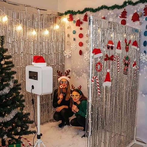 Glamorous party corner featuring silver metallic tinsel fringe backdrop, festive props, and bright warm light.