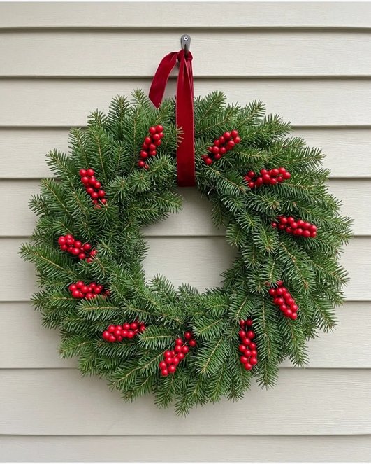 Simple pine red berry wreath on white door