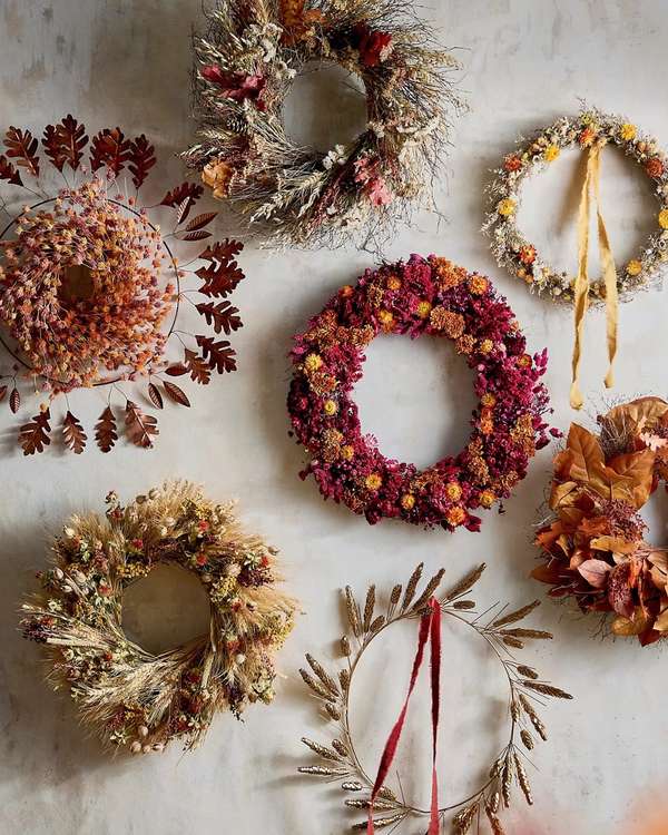 Hallway wall, six small dried foliage wreaths, natural jute twine, soft white paint, recessed ceiling lighting.