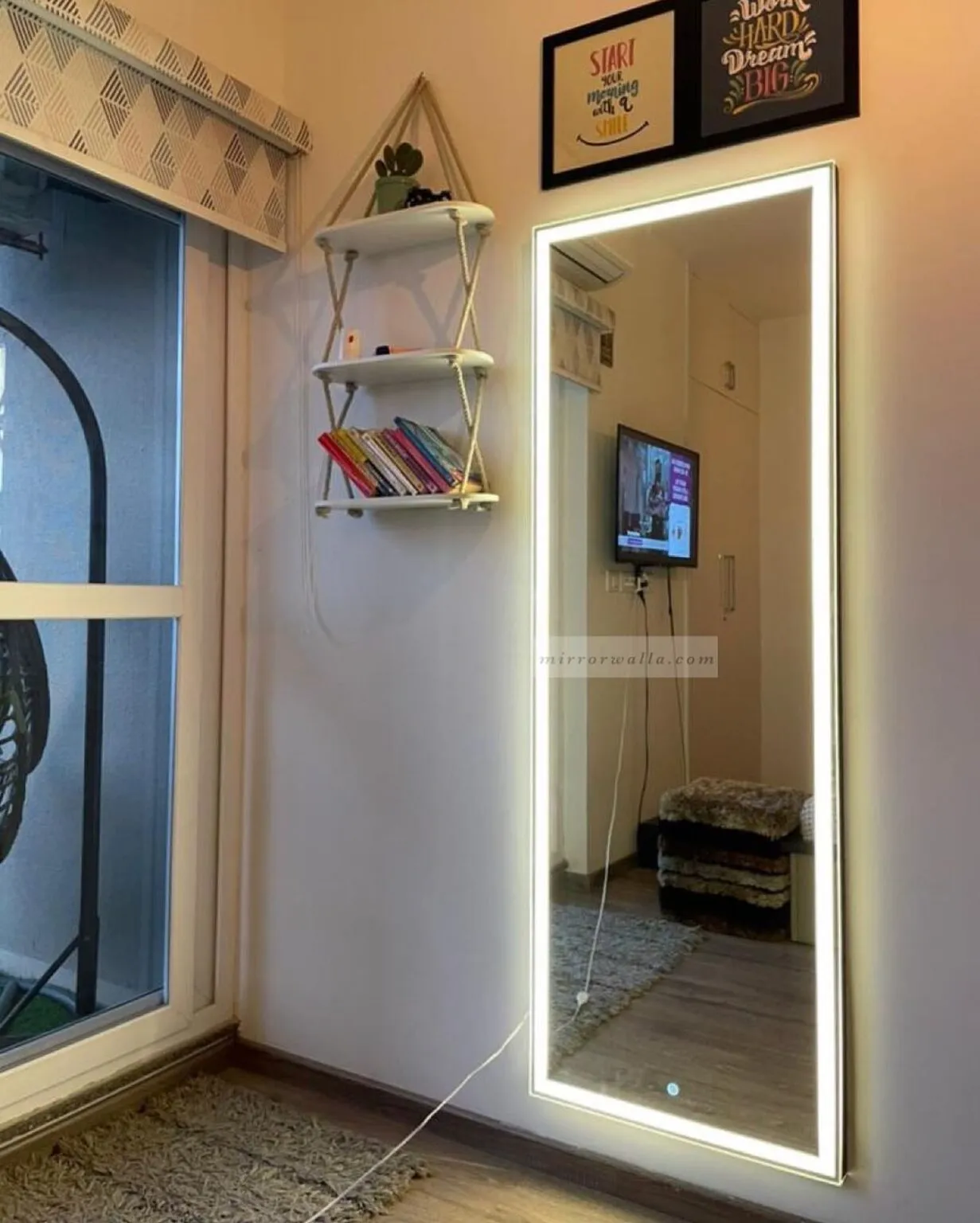 Small living room with full-length LED backlit wall mirror, white walls, and minimal decor in bright lighting.