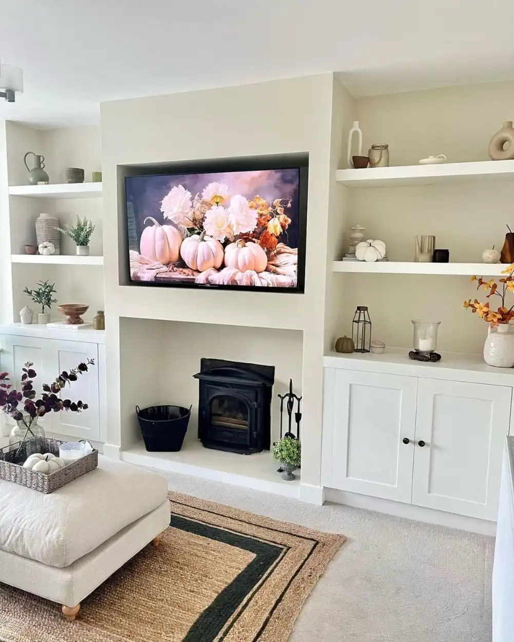 Small living room with media wall, TV, built-in cabinets, and fireplace in a modern, organized setup.