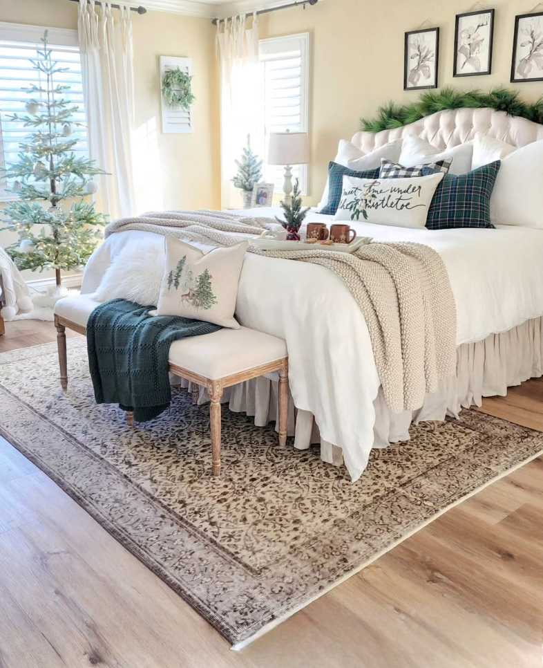 Bedroom with snowy pine branches, soft neutral bedding, and gentle winter light.