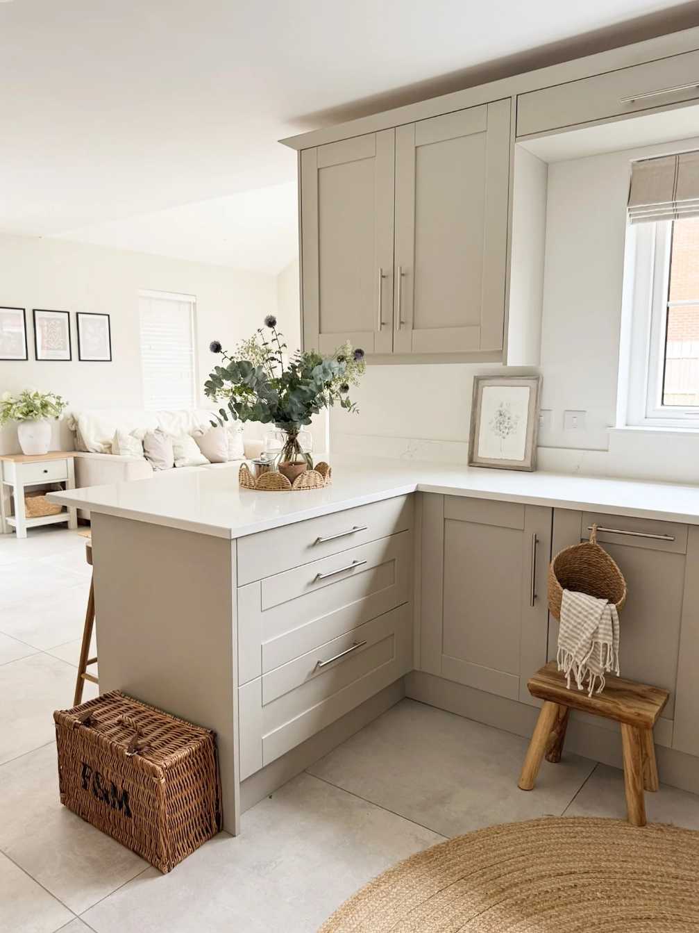 Compact kitchen with greige walls, light walnut cabinets, stainless steel appliances, recessed warm lighting.