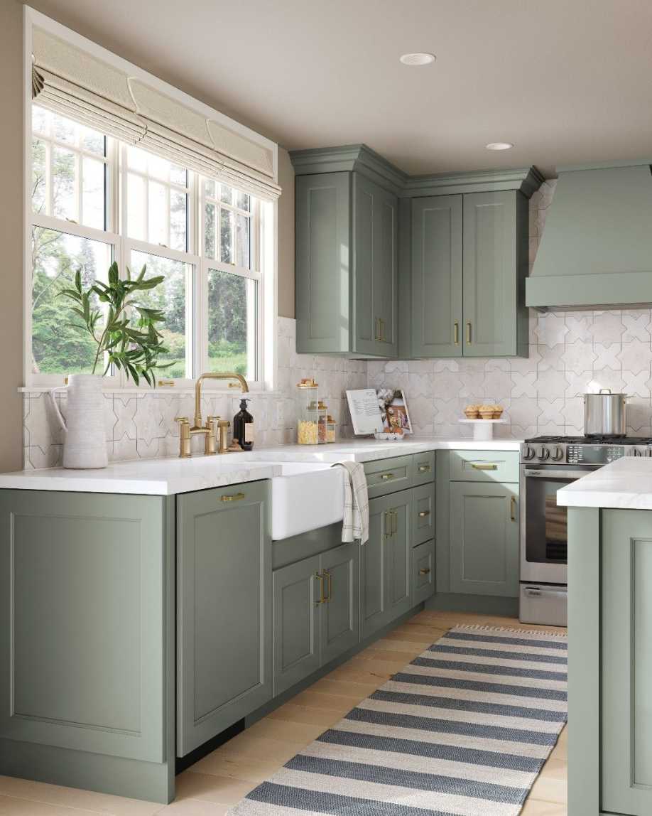 Soft sage cabinets, patterned tile backsplash, brass faucet, warm pendant lighting.