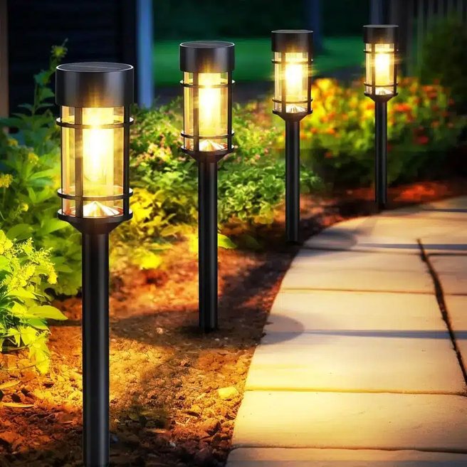 Crushed pea gravel walkway defined by modern black solar path lights casting warm circular glow.