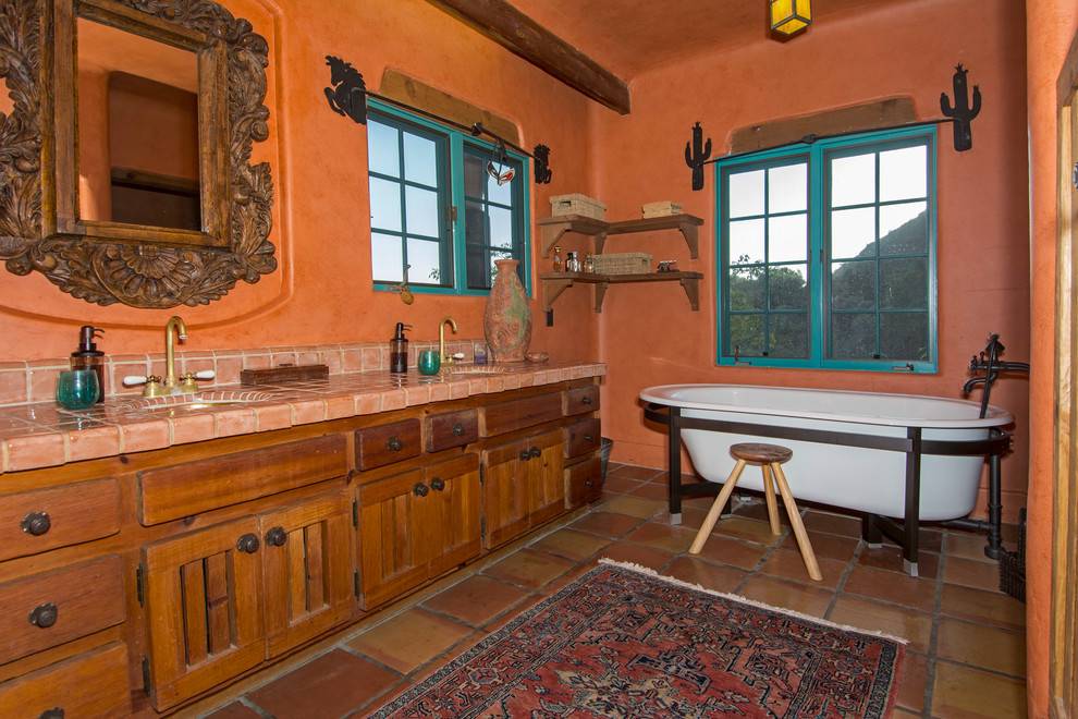 Southwestern bathroom with beehive kiva fireplace, dark slate flooring, soaking tub, warm soft glow lighting.