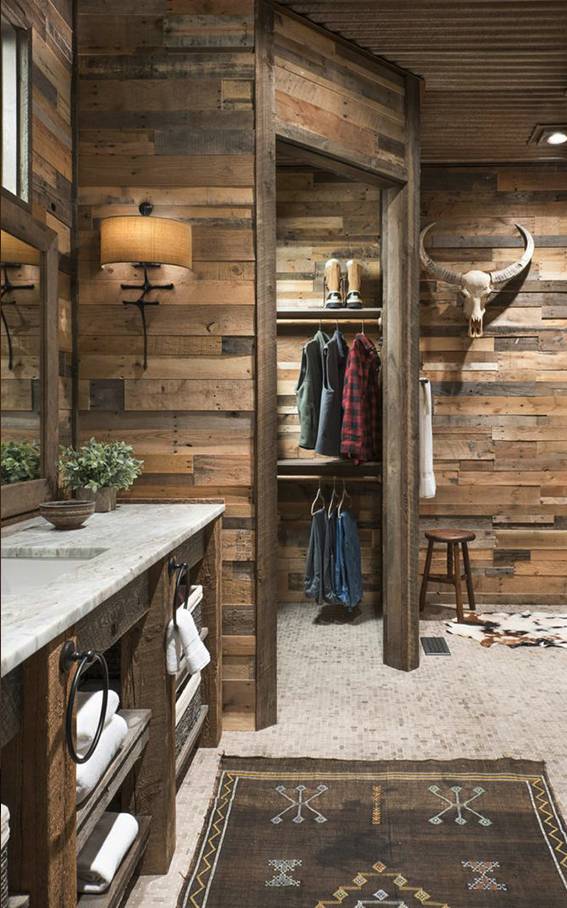 Southwestern style bathroom featuring sage green plaster arch, marble vanity top, wrought iron sconces, natural wood.