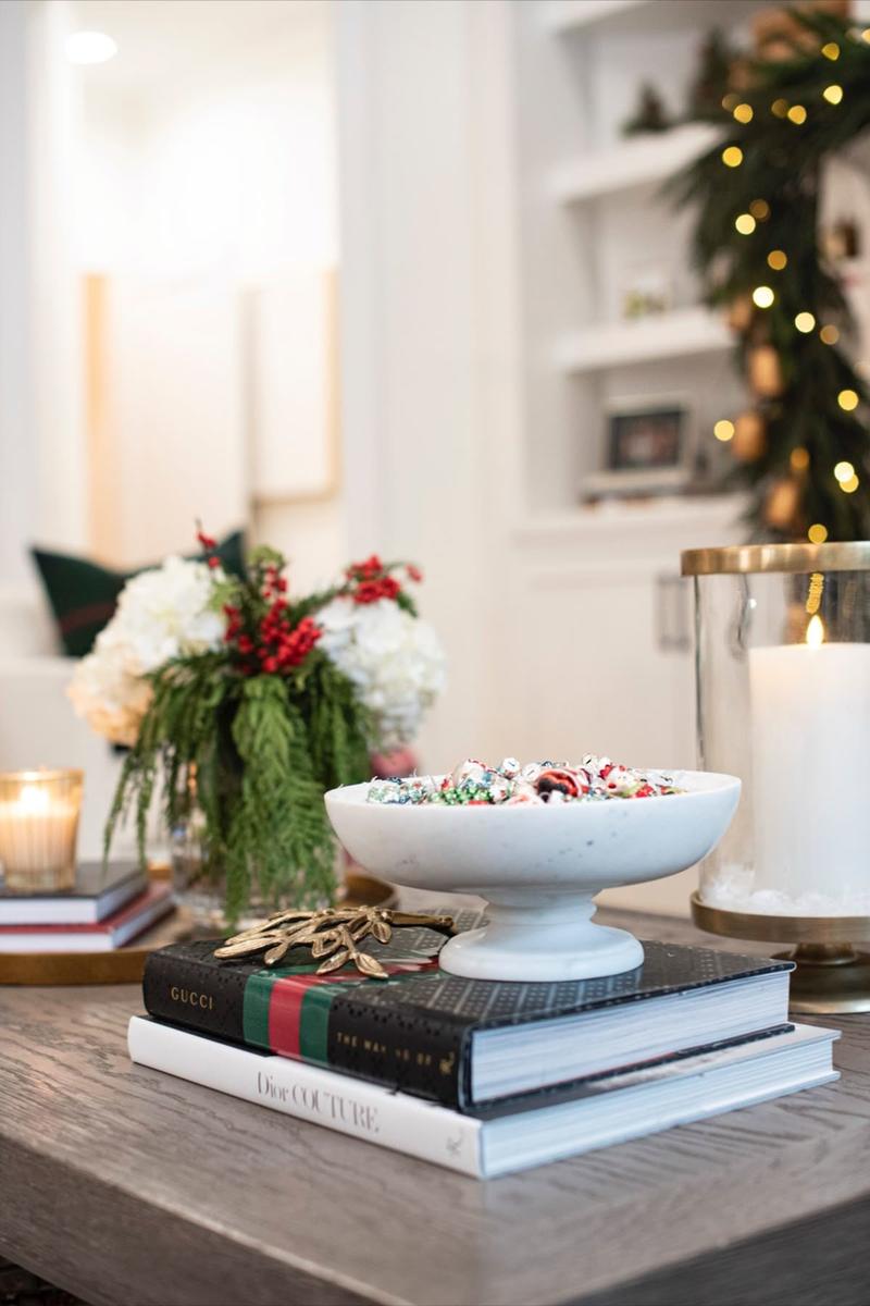 Enchanting Christmas coffee table display featuring sparkling fairy lights inside a glass hurricane jar with greenery.