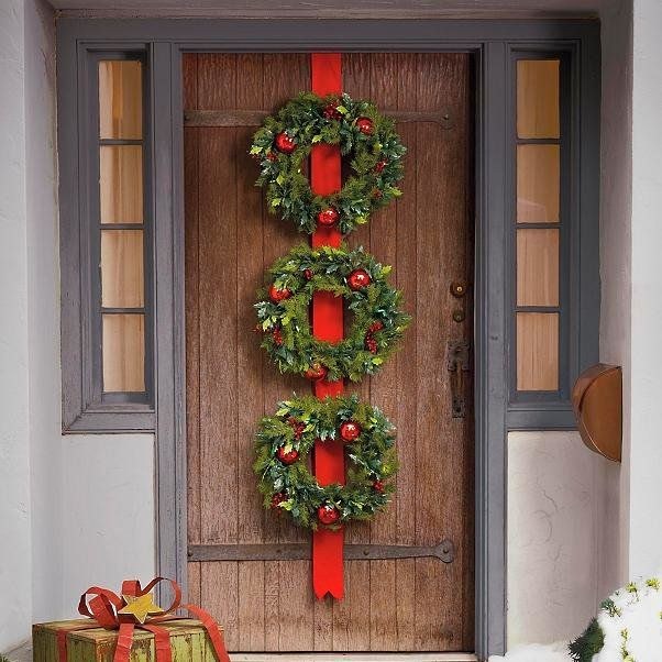 Three wreaths stacked vertically to create a grand holiday entrance display.