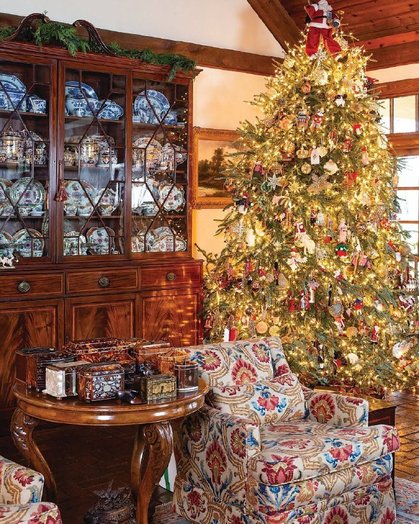 Entry door with oversized wreath, tartan ribbon bow, brass ornaments, soft daylight.