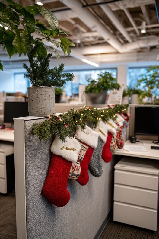 A row of small stockings with name tags hanging on a wall.