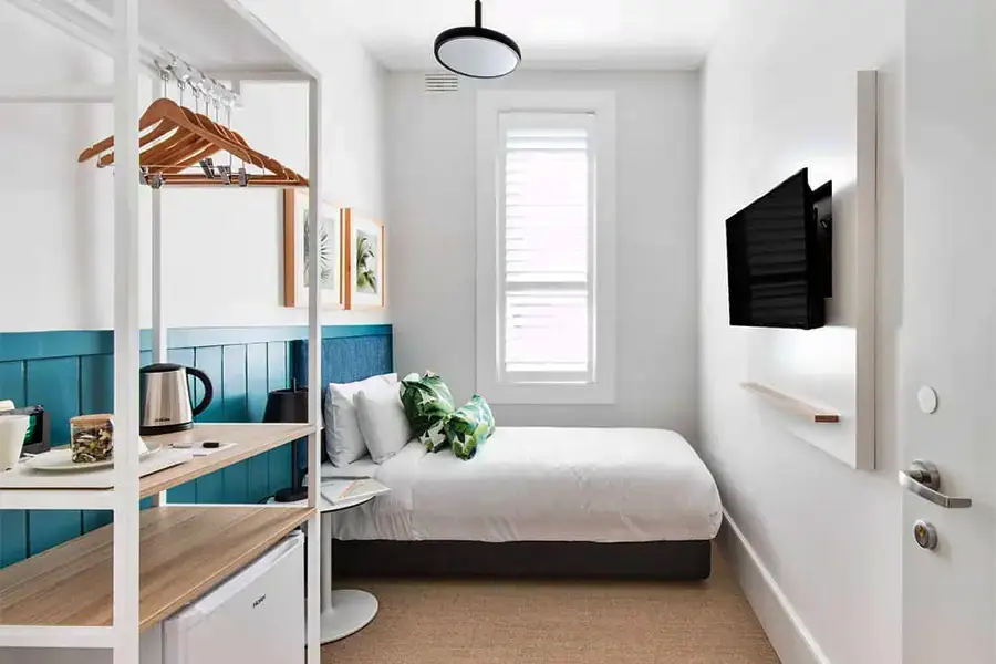 White bedroom layout with built‑in storage units, clean lines, and subtle accent lighting.