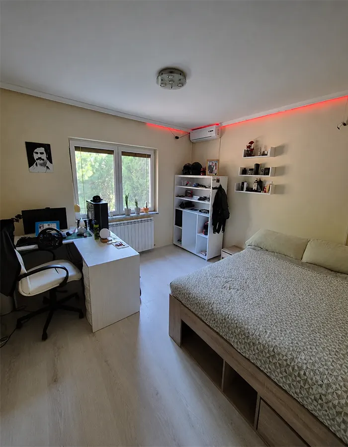 Minimalist bedroom with subtle LED strip lighting along clean white walls and modern furnishings.