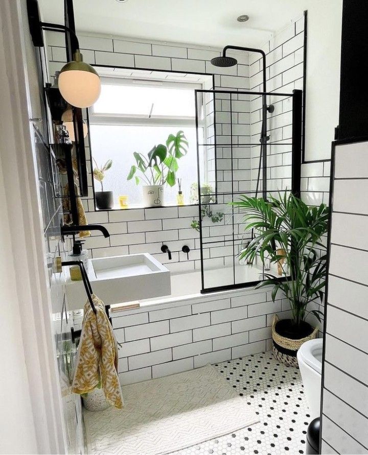 Bathroom featuring classic white subway tiles, a black grid metal shower screen, chrome fixtures, and a matte gray floor.